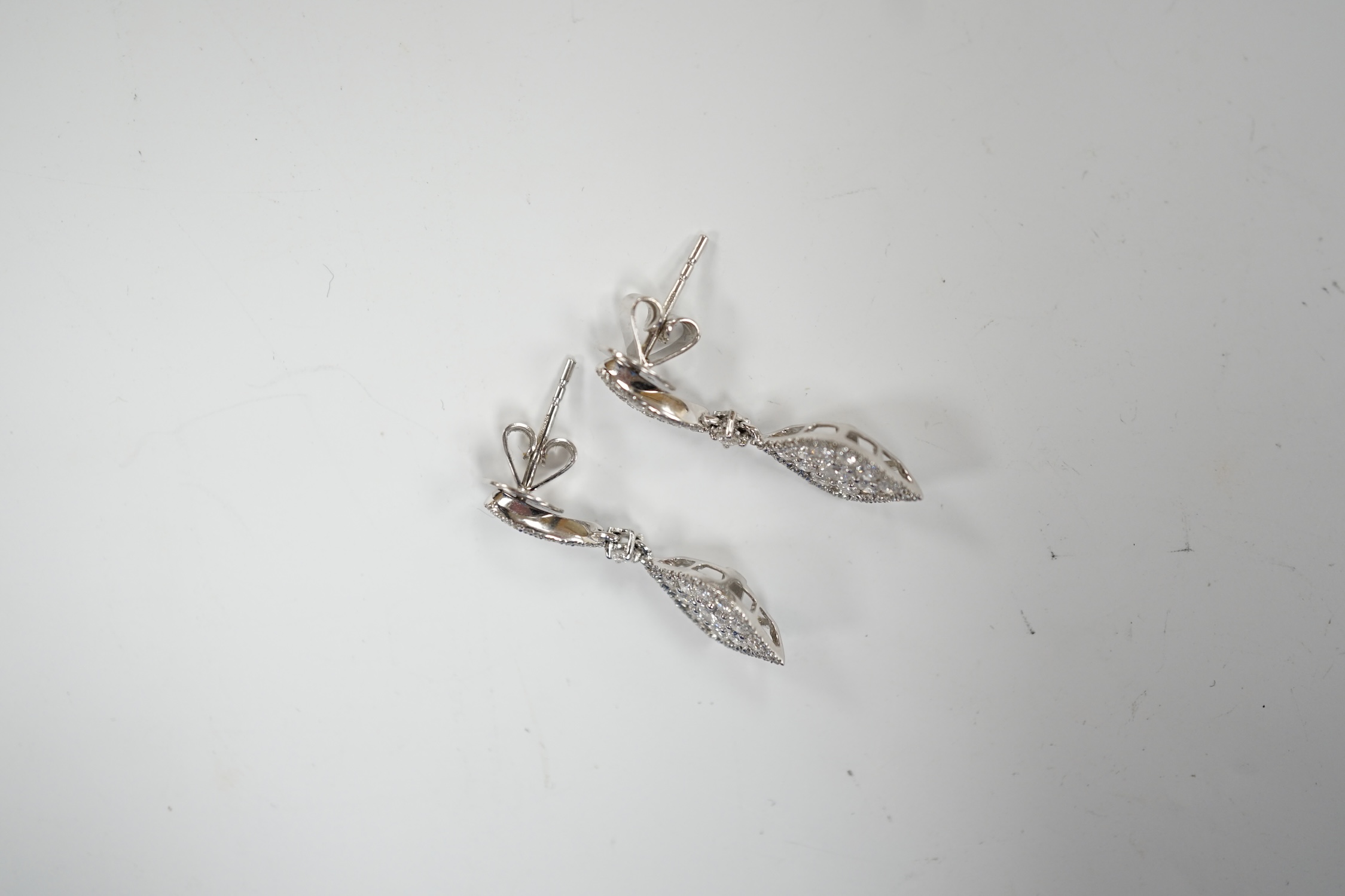 A modern pair of 750 white metal and diamond cluster set drop earrings, of elliptical form, 26mm, gross weight 4.1 grams.